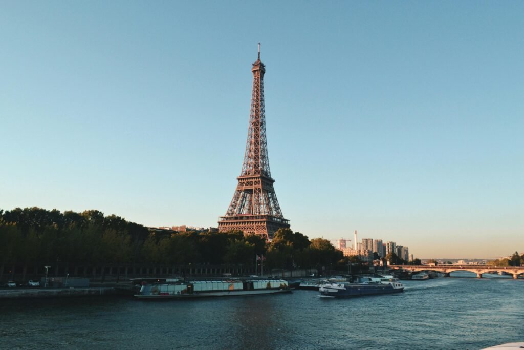 Nos destinations Scenic view of the Eiffel Tower and Seine River at sunset, showcasing iconic Parisian architecture.
